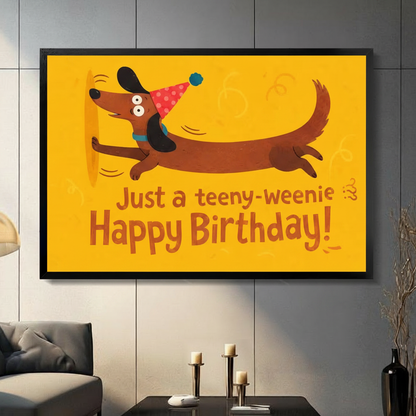 Funny dachshund in party hat framed canvas wall art with happy birthday quote displayed in modern living room above grey sofa
