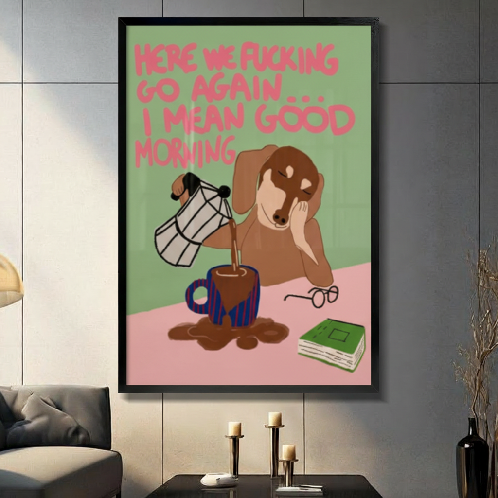Black framed funny sleepy dachshund pouring coffee canvas art with a drowsy brown wiener dog resting its cheek while spilling coffee from a moka pot, glasses and a green book nearby, and a bold pink here we go again I mean good morning quote on a green and pink background, displayed on a dark gray tile wall above a black table with candlesticks beside a gray sofa