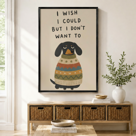Black framed funny dachshund I Wish I Could But I Don't Want To quote canvas art with a grumpy black dachshund in a colorful striped sweater, displayed above a rattan storage console in a bright entryway