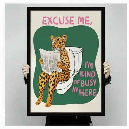 Funny leopard on toilet framed canvas art held up against a light gray background, featuring bold pink quote text and a cheeky cartoon cheetah reading "The Wild News" newspaper