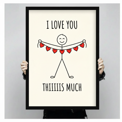 Person holding a black framed I Love You Thiiiis Much stick figure art print with red heart banner against a light gray backdrop