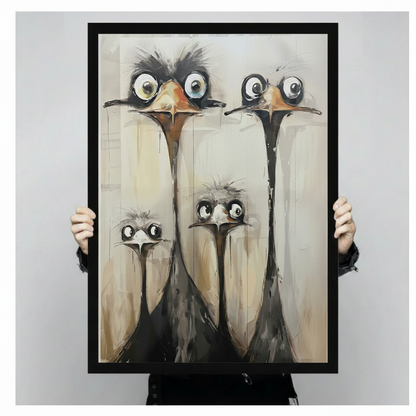 Person holding a large black framed funny ostrich family canvas art print showing print size scale and detailed oil painting texture of four big-eyed ostriches with dark ruffled feathers on warm beige background