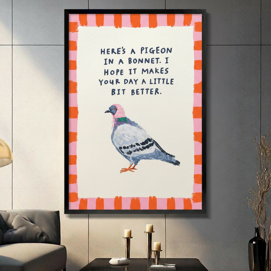 Funny pigeon in a pink bonnet with cheerful quote illustration framed wall art print with orange and pink striped border displayed in a living room with gray sofa, pillar candle holders, and black decorative vase against dark gray tiled wall