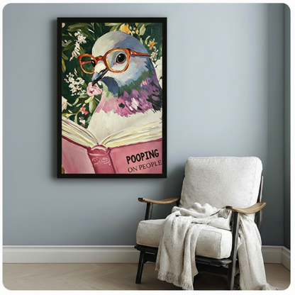 Witty glasses-wearing pigeon reading Pooping on People book framed art poster with colorful floral background displayed beside a white linen lounge chair with draped throw blanket against a soft blue-gray wall