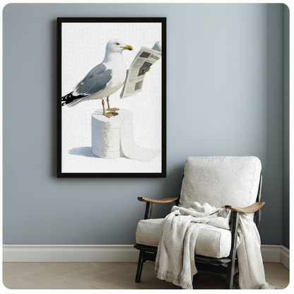 Humorous seagull bird reading newspaper canvas print in black frame, hung on a light blue-gray wall above a wooden armchair with a cream throw blanket