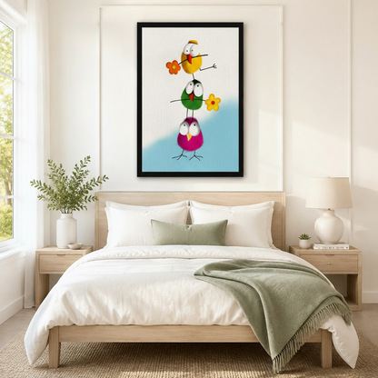 Black framed funny stacked birds with flowers canvas art with three fluffy round cartoon birds — yellow green and magenta — stacked tall and holding orange and yellow daisy flowers on a soft white and sky blue background, hung above a light wood bed with white linen bedding and a sage green throw in a serene Scandinavian bedroom