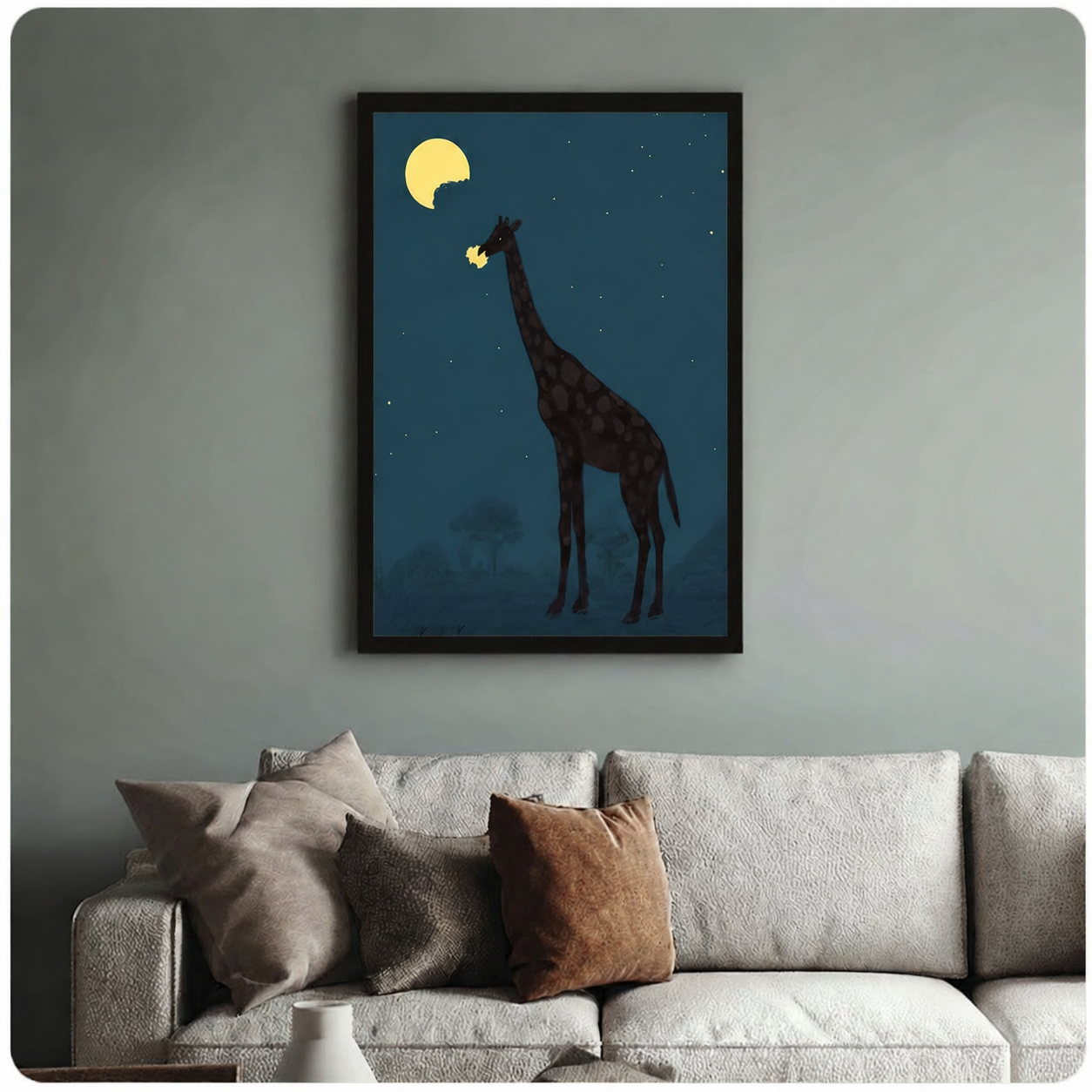 Black framed canvas art of a giraffe eating the moon in a whimsical night scene, hung above a neutral linen sofa on a sage green wall