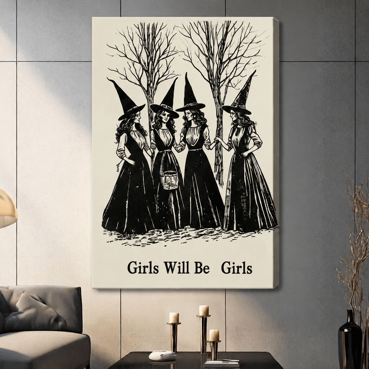 Gallery wrapped canvas art featuring four witches in vintage black gowns and tall pointed hats gathered in a forest, Girls Will Be Girls text below, hung in a warm-toned living room setting