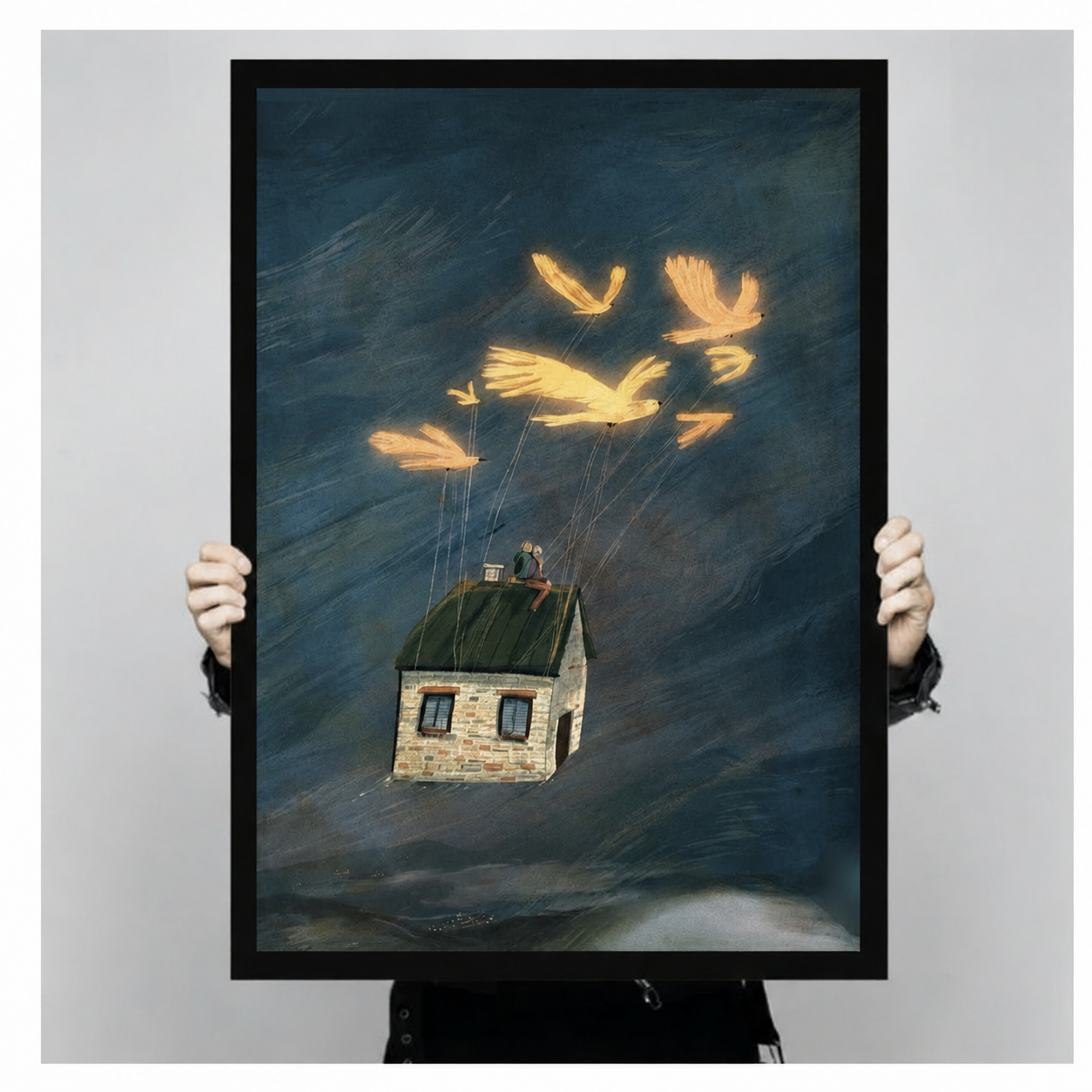 Hand-held framed canvas showing luminous golden birds lifting a stone house with two figures on the roof against a deep teal stormy background