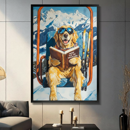 Funny golden retriever wearing blue aviator sunglasses reading Made for the Mountains book on orange ski lift chair with yellow skis and snowy mountain backdrop oil painting framed wall art print displayed in a living room with dark gray sofa, pillar candle holders, and black decorative vase