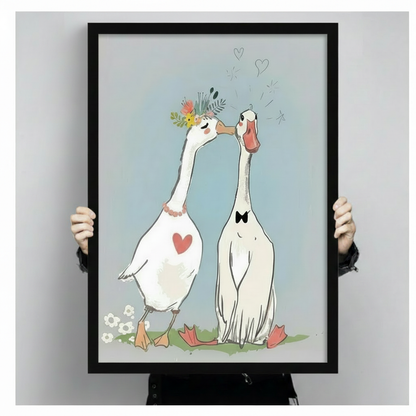 Romantic goose couple kissing framed art print held up to show full size, whimsical illustration with floral crown, bow tie and floating hearts