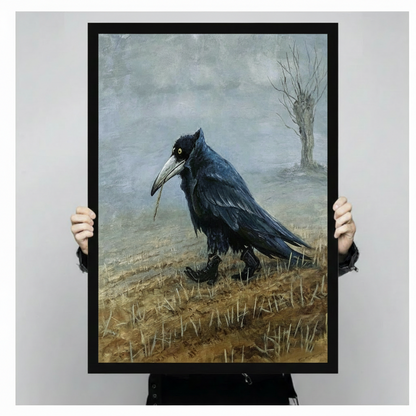 Gothic raven moody landscape impasto canvas wall art in black float frame held by person against neutral gray background, atmospheric wildlife portrait of solitary raven mid-stride through dry golden grass with misty blue-grey sky and bare winter tree