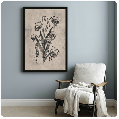 Black framed gothic skull botanical canvas art print with five human skulls on a lily of the valley stem and dark hanging berries in vintage charcoal illustration style on aged beige background beside a white linen armchair