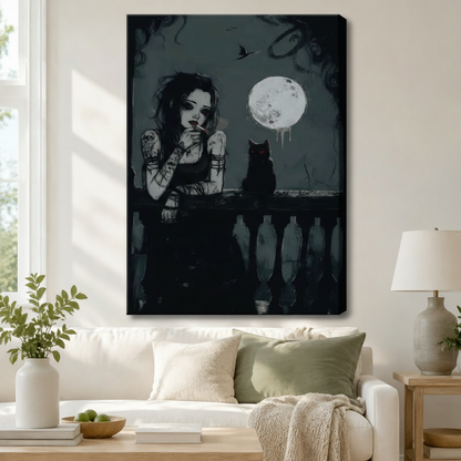 Gallery wrap canvas art featuring a moody dark illustration of a tattooed gothic woman and a black cat on a balcony beneath a dripping full moon with a raven in the background, hung above a white sofa in a modern living room