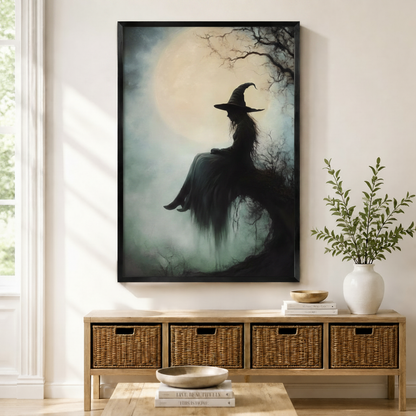 Gothic witch silhouette seated under full moon misty forest oil painting art print in black frame above wicker console in neutral entryway