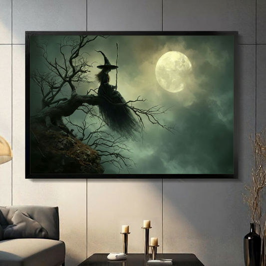 Gothic witch sitting on dead tree under full moon framed wall art displayed in a modern living room with gray sofa and candlesticks