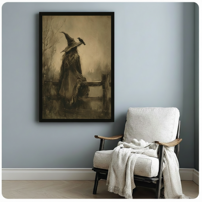 Gothic witch seated on fence with raven dark fantasy framed canvas art in black float frame on blue-gray wall beside white linen armchair with throw blanket