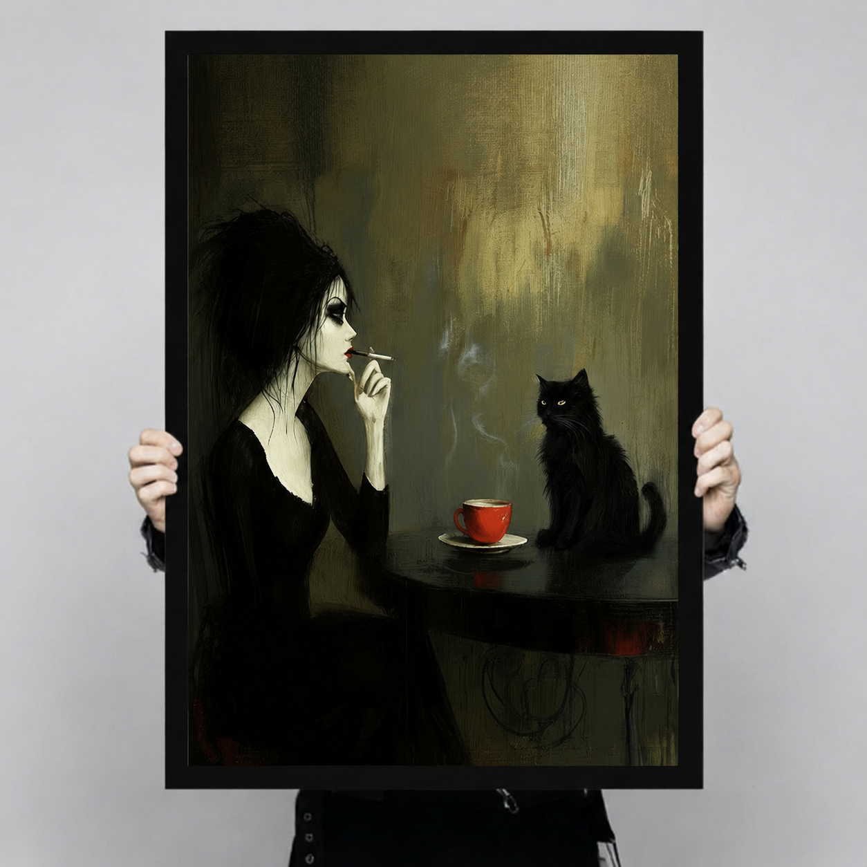 Hand-held display of a black-framed canvas art print featuring a gothic pale woman smoking a cigarette facing a mysterious black cat beside a red coffee cup on a dark textured olive-gold background — dark academia wall art