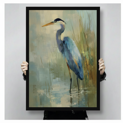 Close-up of a black framed great blue heron oil painting print held by two hands, showcasing brushstroke texture and muted teal and gold tones