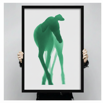 Close-up of abstract green whippet silhouette framed art print held by hands – modern animal wall art showing print size and detail