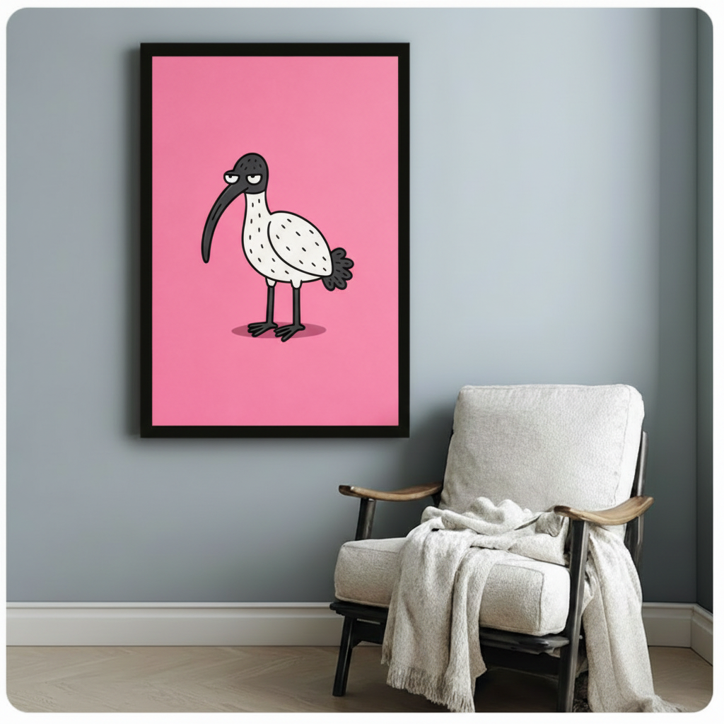 Black framed cartoon grumpy ibis on a bright pink background hung on a blue-grey wall beside a white upholstered armchair draped with a white throw blanket, bold whimsical bird wall decor for a cosy reading nook