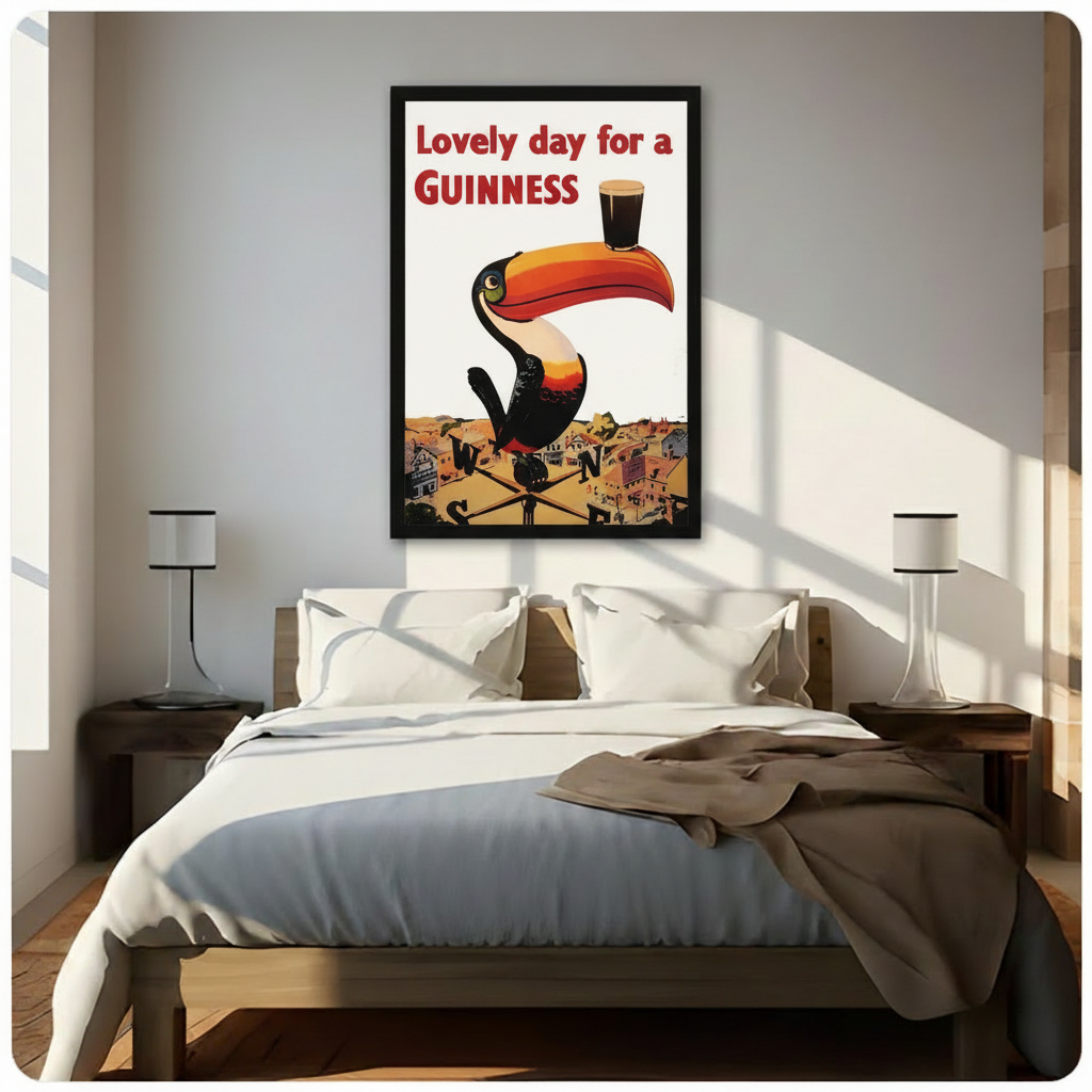 Framed Guinness toucan retro advertising poster mounted above a bed in a bright minimalist bedroom, classic bar wall art decor
