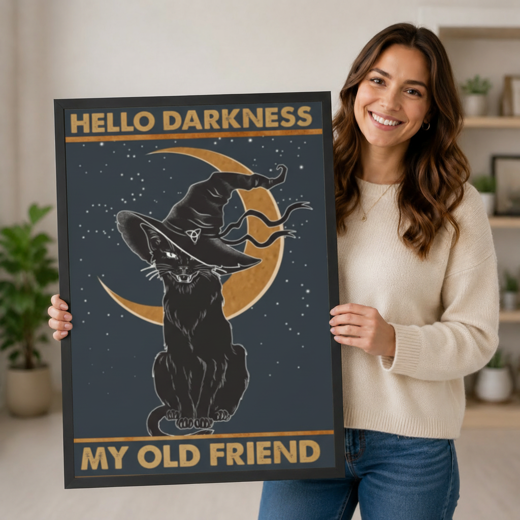 Smiling woman holding large black framed Hello Darkness My Old Friend gothic witch cat crescent moon art print in bright home interior lifestyle photo