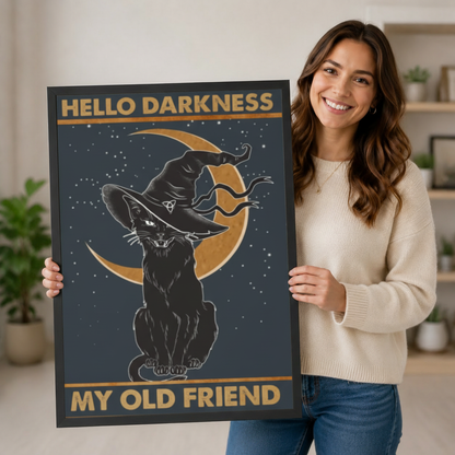 Smiling woman holding large black framed Hello Darkness My Old Friend gothic witch cat crescent moon art print in bright home interior lifestyle photo