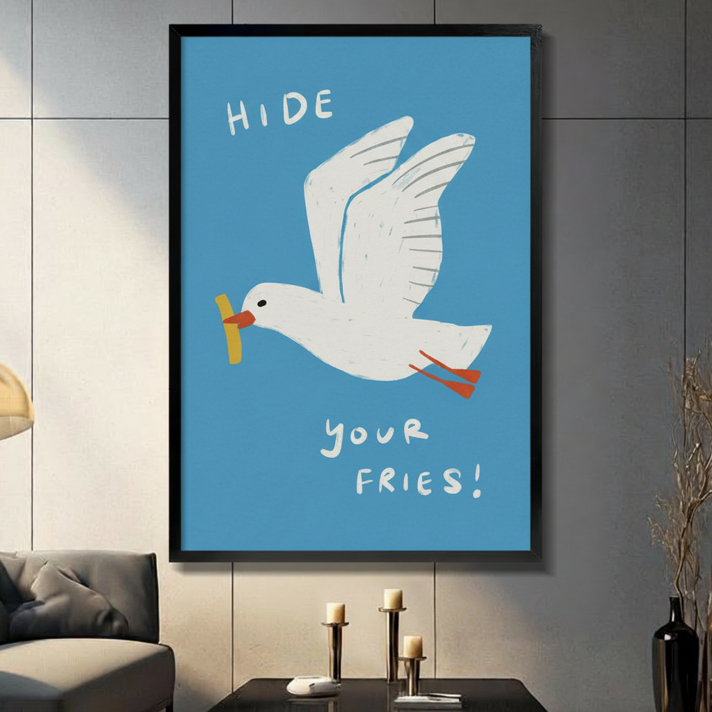 Funny "Hide Your Fries" seagull wall art print with blue background, white gull carrying a chip in its beak, displayed in black frame on dark grey wall