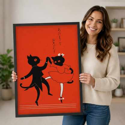 Smiling woman holding a large black framed vintage Japanese dancing cat couple art print on bold red background, showing scale for home decor gifting