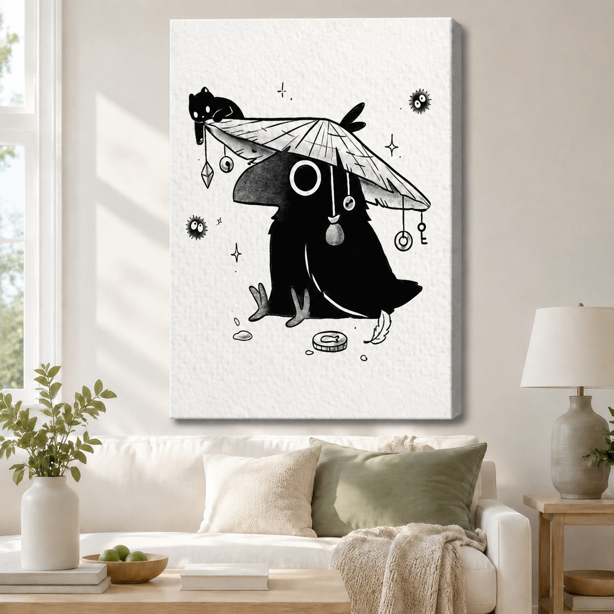 Unframed canvas print of a whimsical ink-style crow wearing a conical straw hat with a black cat perched on top and mystical key and orb pendants, hung above a white sofa in a cozy neutral living room