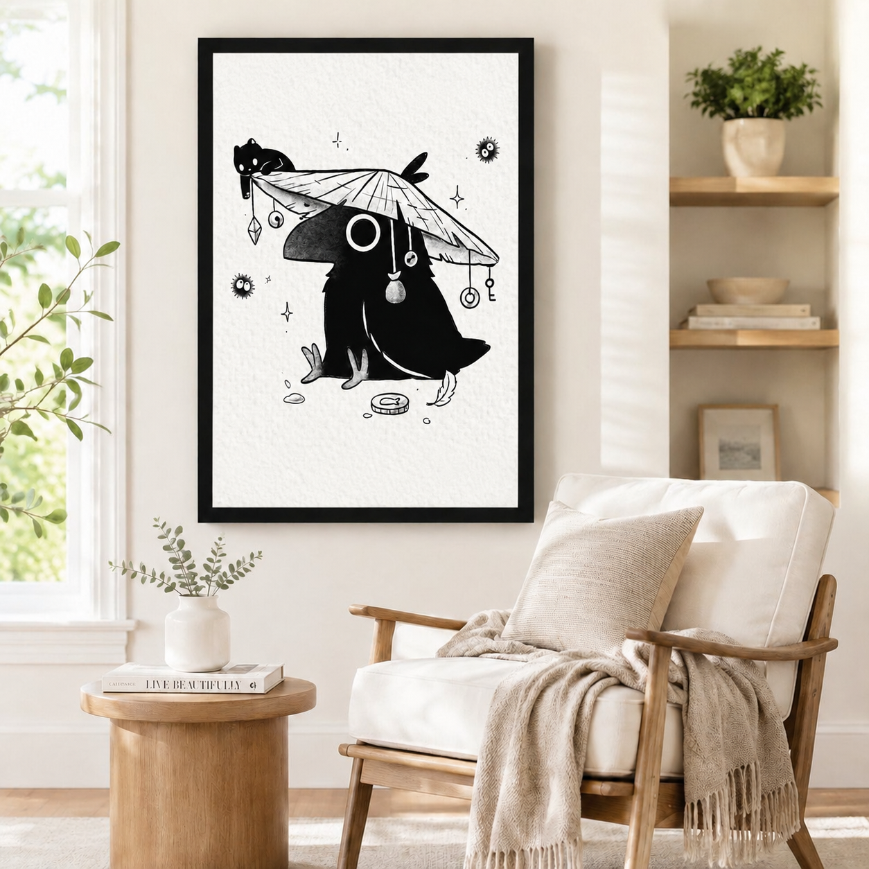 Framed black-and-white Japanese crow art poster with straw hat, sleeping cat, and hanging charm details, styled beside a linen armchair and round side table in a minimalist reading nook