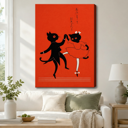 Stretched canvas wall art of a vintage Japanese black cat couple dancing on a bold red background, displayed above a white sofa with sage green cushions and a ceramic table lamp