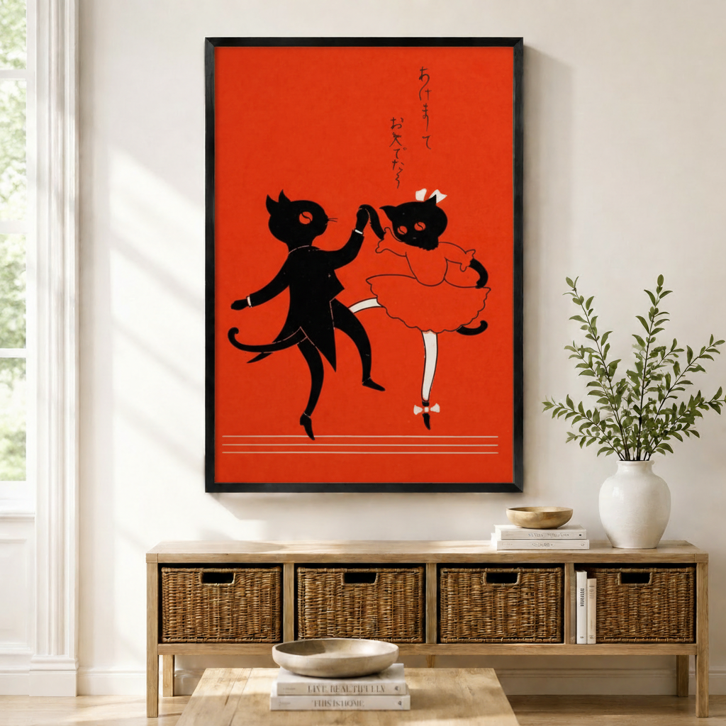 Black framed Japanese retro dancing cat couple wall art above a wicker storage console with white ceramic vases and green branches in a bright minimal entryway