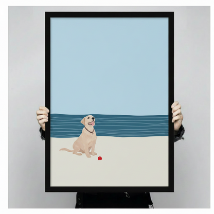 Hand-held black framed canvas print of happy yellow labrador sitting on sandy beach with red ball
