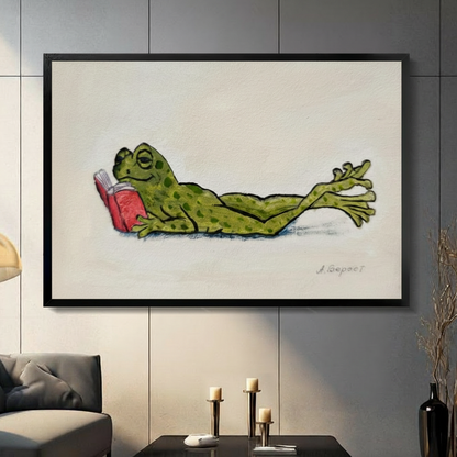 Whimsical lazy frog reading red book framed canvas wall art with black wood frame displayed in modern living room with gray panel wall and candlesticks