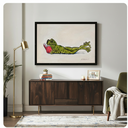 Framed whimsical lazy frog reading book canvas art hung above dark walnut sideboard in modern living room with brass floor lamp and green velvet accent chair