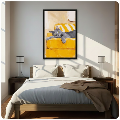 Framed oil painting style canvas wall art of a lazy grey cat lounging on a yellow couch hung above a wooden bed with white bedding in a bright sunlit minimalist bedroom