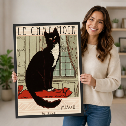 Smiling woman holding large black framed Le Chat Noir Miaou vintage French black cat art nouveau wall art print in bright home interior lifestyle photo