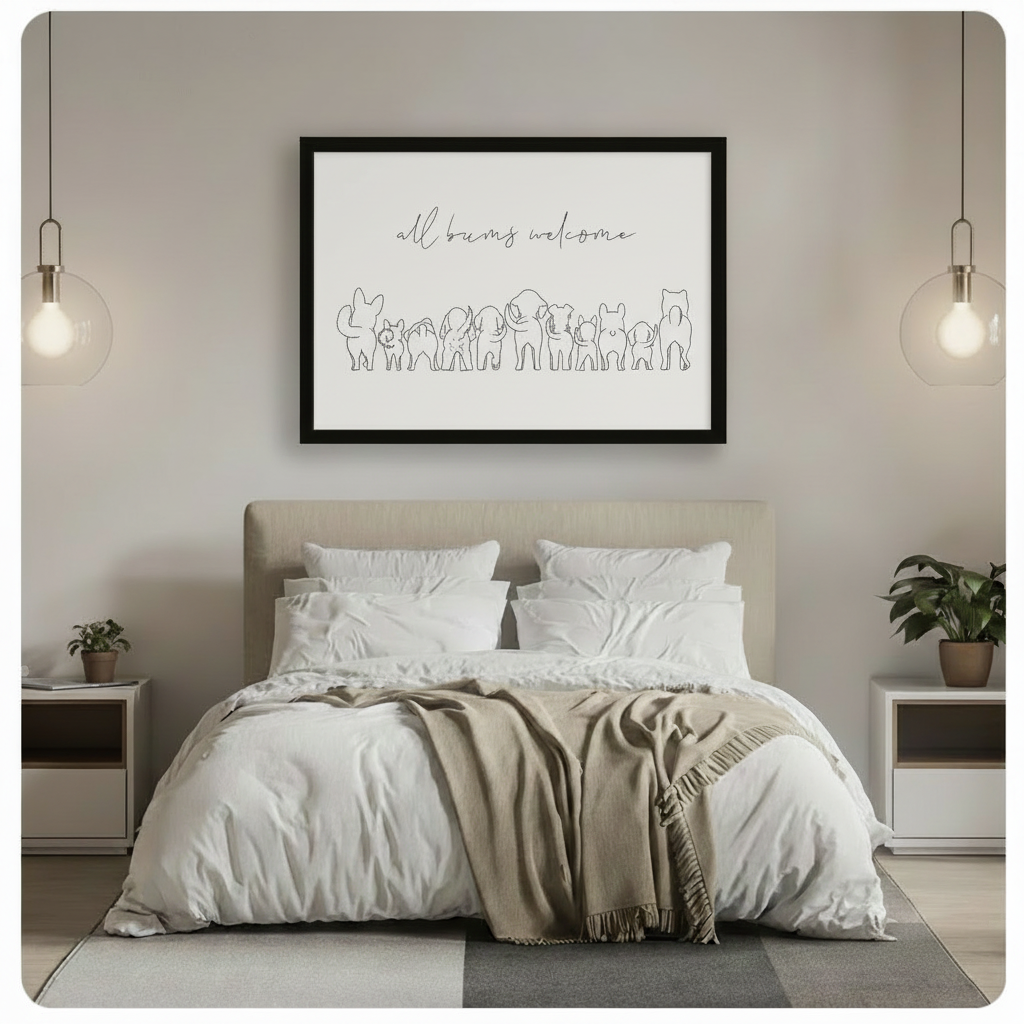 Black framed minimalist all bums welcome animal line art canvas art with graceful script lettering above a whimsical row of animal rear silhouettes including a rabbit, cat, dogs, elephant, pig, and French bulldog in clean single-line black illustration on a white background, hung above a beige upholstered bed with crisp white linen bedding, a taupe throw blanket, white nightstands, potted plants, and globe pendant lights