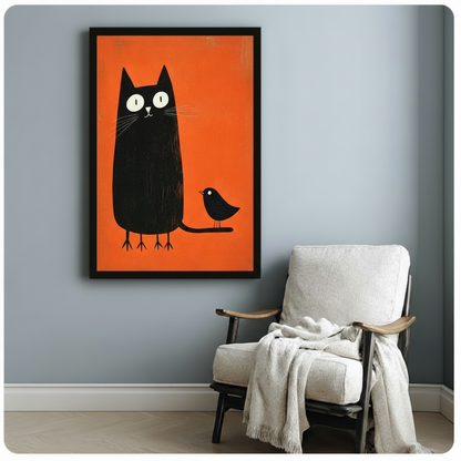 Black framed minimalist black cat and bird orange art print on a light grey wall beside a white linen armchair draped with a white throw blanket, bold whimsical animal wall decor for a cosy reading corner