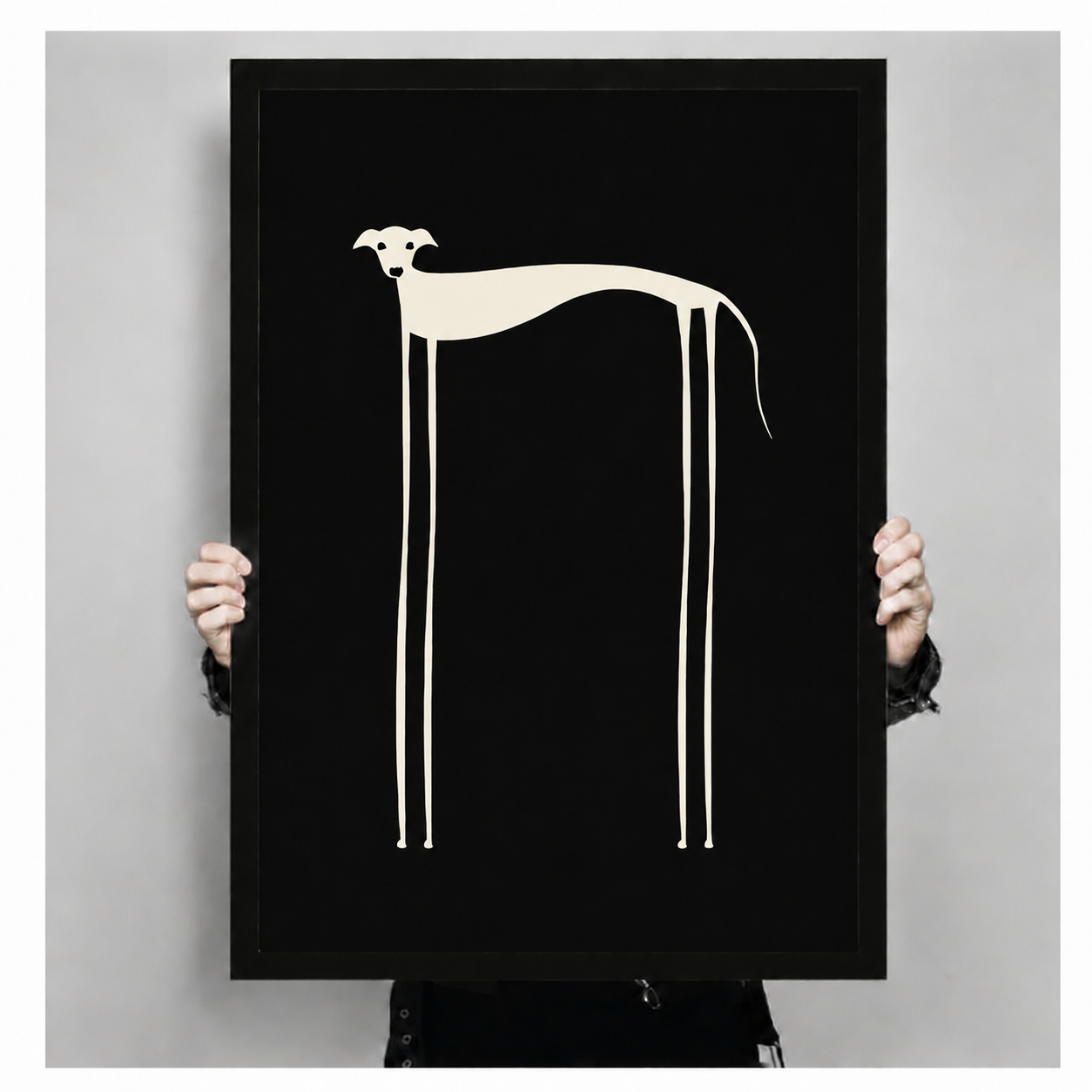 Hand-held front view of minimalist long-legged dog poster in black frame on white background