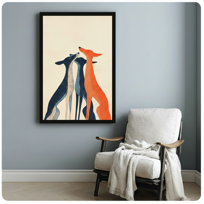 Black-framed minimalist art print of three slender greyhounds in navy blue and burnt orange, styled beside a white armchair in a light blue-gray reading nook