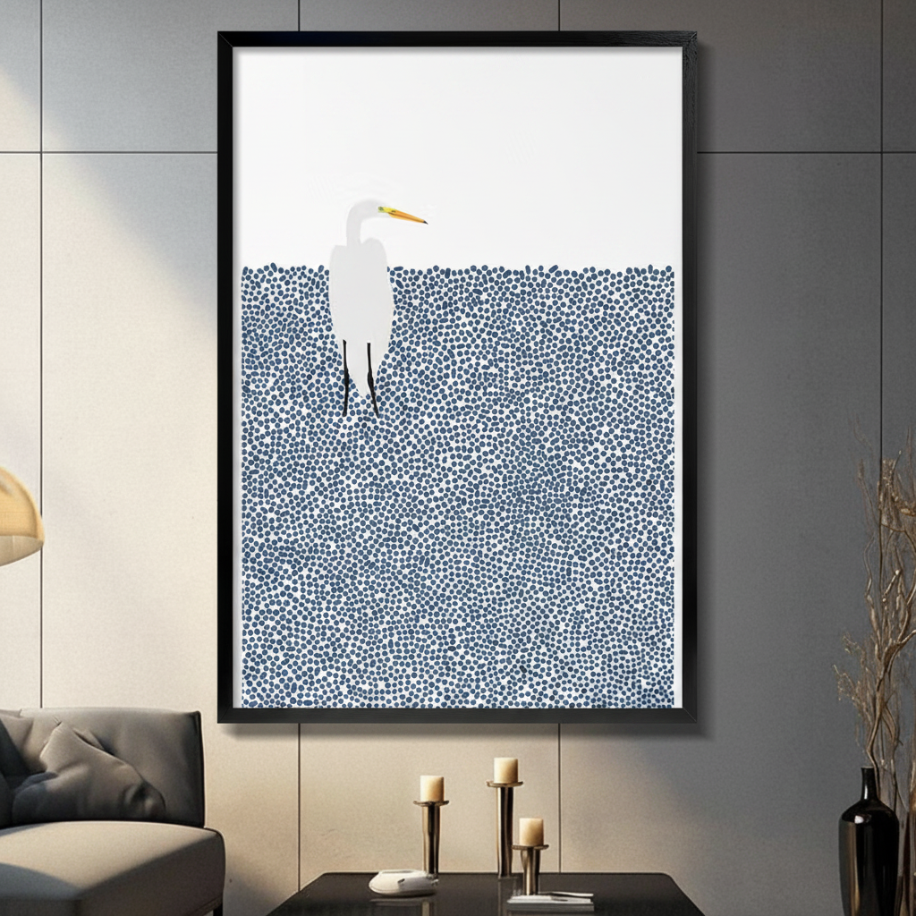 Framed minimalist white egret standing in dotted navy blue water wall art displayed above a console table with candlesticks in a contemporary dark grey living room