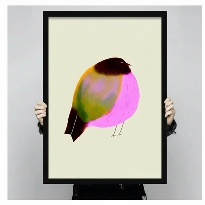 Hands holding a large black framed canvas print of a bold illustrated bird with neon pink and olive-green plumage on soft cream background, expressive digital illustration style against a neutral gray backdrop