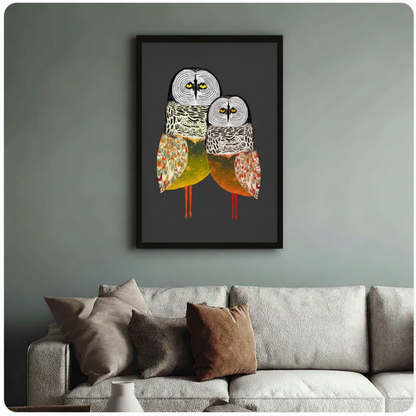 Framed owl duo canvas print above neutral sofa on sage green wall — folk art bird wall art for living room, charcoal background statement piece
