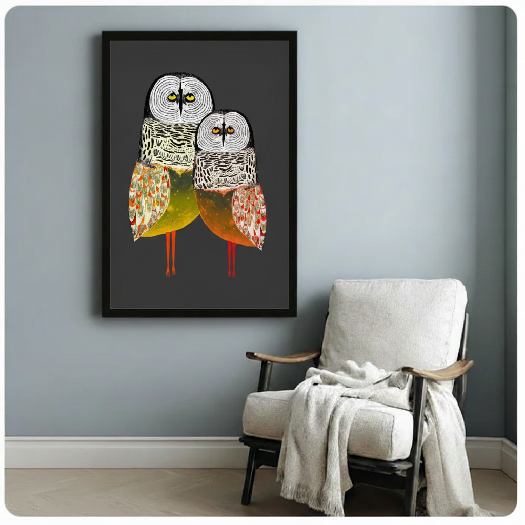 Folk art owl pair framed canvas on grey accent wall beside armchair — vibrant bird illustration with red legs, eclectic home office wall art