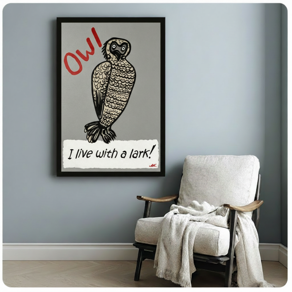 Black framed funny owl typography canvas print featuring a plump wide-eyed owl in expressive linocut illustration style with bold red OW text above and the humorous phrase I live with a lark in black handwriting on a torn white paper strip at the bottom artist signed MK in red on a gray background hung on a blue-gray wall beside a white upholstered wood folding chair with cream throw