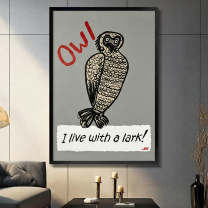 Black framed whimsical linocut style illustration of a wide-eyed round owl with detailed feather texture and the bold red handwritten text OW in the upper left and the phrase I live with a lark in black script on a torn white paper strip at the bottom funny owl humor typography canvas wall art on medium gray background displayed in a modern gray living room with dark sofa and candlesticks