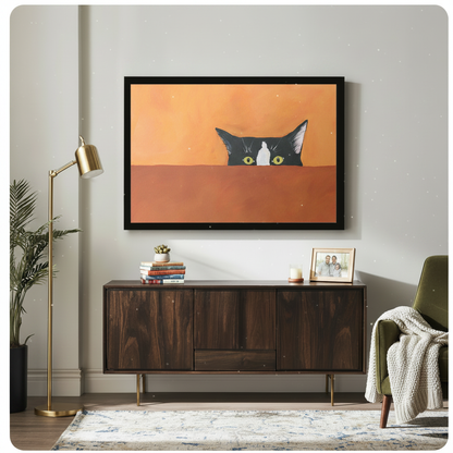 Peeking tuxedo cat wall art in black frame above wooden sideboard in a bright living room with gold floor lamp and green chair